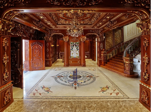Sự kết hợp giữa phù điêu sàn đá và nội thất gỗ tự nhiên tạo nên tổng thể đẳng cấp cho sảnh đón tiếp.