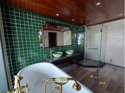 Khu vực phòng tắm cao cấp trên Du thuyền Indochine sử dụng lavabo đá xanh tự nhiên kết hợp chậu đồng ánh vàng, mang phong cách Indochine sang trọng và đậm chất nghỉ dưỡng 5 sao.