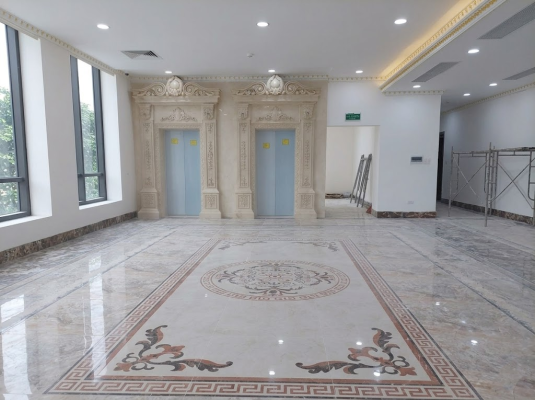 Chi tiết phào chỉ mặt tiền thang máy và sàn thảm đá tự nhiên tại sảnh chờ khách sạn
